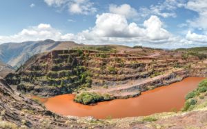 Featured in "Tour Film Locations of Blood Diamond" by Jaya Travel & Tours, this image shows the red terraced ground and a muddy river in South Africa.