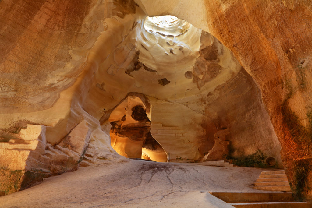 The interior of the Bell Cave in Beit Guvrin National Park, where red sandstone creates beautiful caves and a natural skylight that can be seen in jesus christ superstar as a film locations.