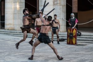 a group of gladiators with swords and gear fight on a street corner like in the movie gladiator.