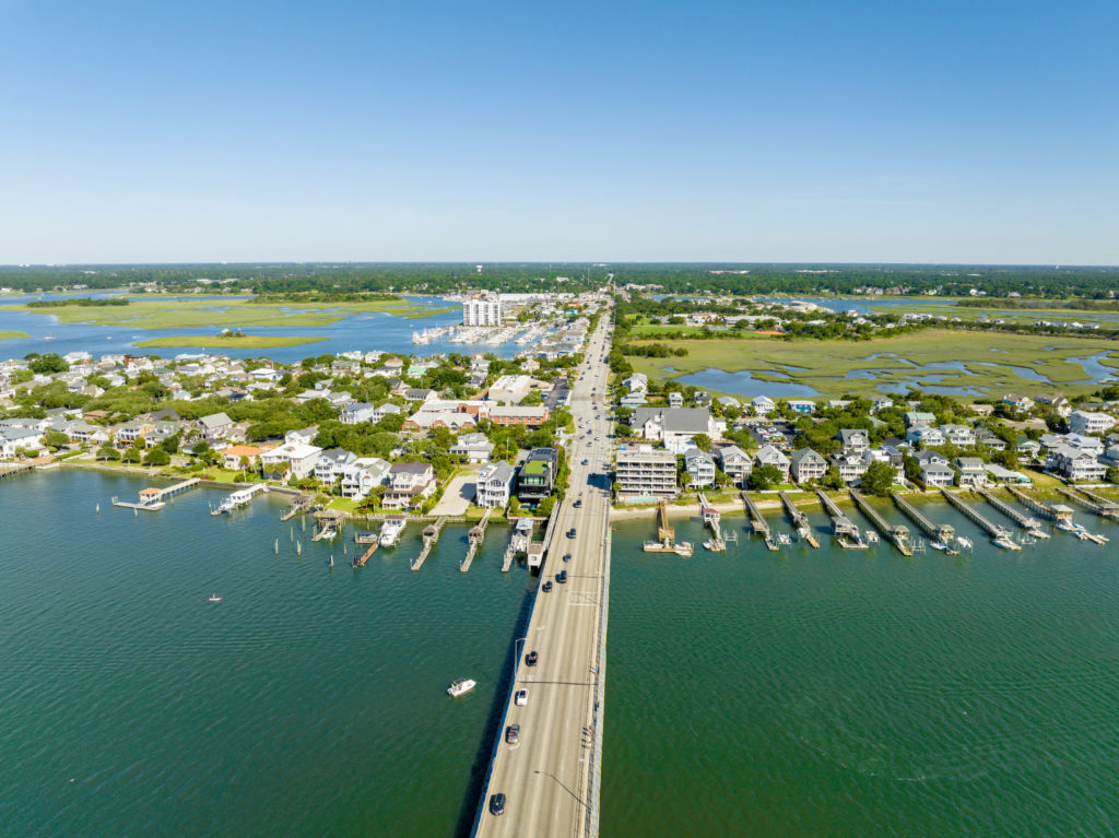 A beautiful landscape shot of the bridge to Wrightsville Beach, North Carolina, in the Outer Banks, which is one of the most popular and scenic driving locations. This image is featured in the Jaya Travel & Tours blog, "A United States Road Trip," which is a travel guide to the best road trips and driving the best highways in America.