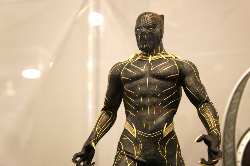 An action figure that looks extremely realistic Black Panther suit placed away behind glass for safe protection. This image is featured in the Jaya Travel & Tours blog post, "On Location: Black panther & Wakanda Forever," which lists the filming destinations of the popular marvel movie series.
