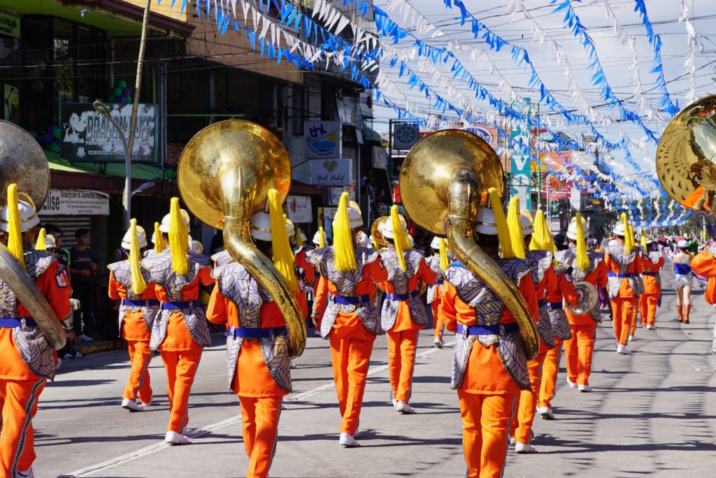Featured in "Thanksgiving Parades in the US" by Jaya Travel & Tours, this image shows a marching band on a parade route.