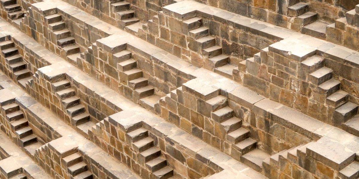 Featured in the blog "The Dark Knight Rises Film Locations" by Jaya Travel & Tours, this image shows the step wells of Chand Baori in Rajasthan, India.